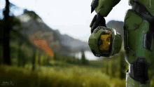 a halo infinite poster with a man in a green suit holding a helmet