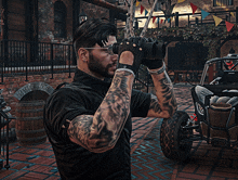 a man in a black shirt is looking through binoculars