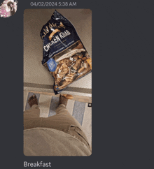 a bag of chicken kebab is on the floor next to a person