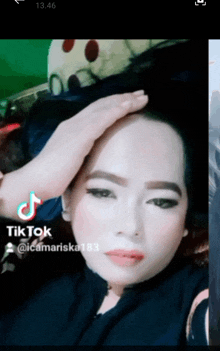 a woman 's face is shown with a tiktok sticker