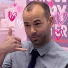 a man in a striped shirt and tie is giving a thumbs up .