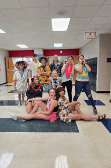 a group of people posing for a picture in a hallway with a sign above them that says " the lockers "