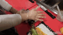 a person wearing plastic gloves is preparing food on a cutting board with the words made in animotica on the bottom