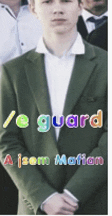 a man in a green suit stands in front of a sign that says / e guard a isom motion