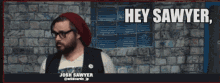 a man with a beard wearing glasses and a beanie says hey sawyer