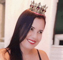 a woman wearing a crown on her head smiles for the camera