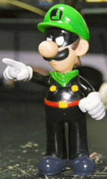 a figurine of a cartoon character with a green hat and a letter j on it