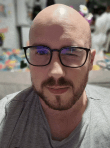 a bald man with a beard wearing glasses