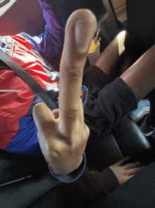 a person sitting in a car with their middle finger up