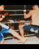 two men are boxing in a ring and one of them is kicking the other