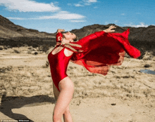 a woman in a red swimsuit is standing in the desert