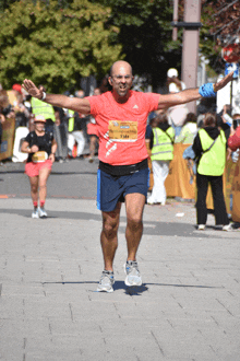 a man in a red shirt with the number 731 on it is running