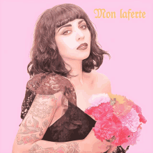 a woman with a tattoo on her arm is holding a bouquet of flowers in front of a pink background with the words mon laferte