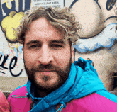 a man with a beard wears a blue jacket in front of a sign that says ' non-violent area '