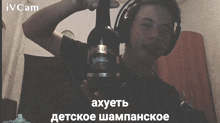 a man wearing headphones is holding a bottle of wine with a label that says " axuetb "