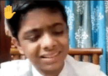 a young boy is sitting in a chair with his eyes closed and a hand behind his head .