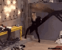 a woman in a black outfit is dancing in a room with johnnych written on the bottom