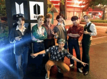 a group of young men are posing for a photo in front of a sign that says army