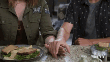 a man and a woman holding hands in front of a plate of food with netflix written on the bottom