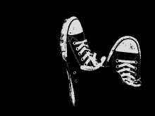 a pair of black and white sneakers on a black background