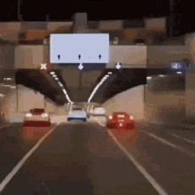 cars are driving through a tunnel with a sign above them that says x