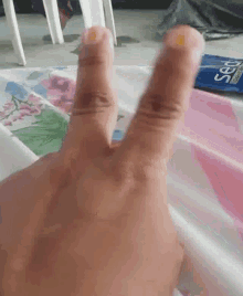 a close up of a person 's hand with their fingers crossed in front of a box of shaving cream