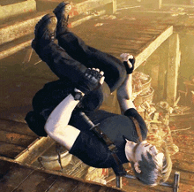 a man in a black shirt is laying upside down on the floor