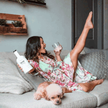 a woman laying on a couch holding a bottle that says tonic water