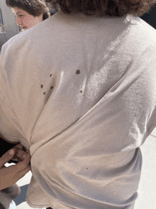 a person wearing a white shirt with holes in the back