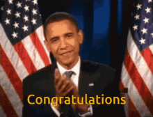 a man in a suit and tie applauds in front of an american flag with the words congratulations written in yellow