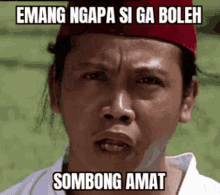 a man wearing a red hat with the words emang ngapa si ga boleh sombong amat on his face