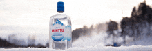 a bottle of minttu peppermint vodka sits in the snow