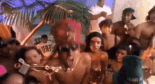 a group of people are standing around a man in a bikini .