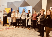 a group of women standing in front of a large screen with a circle on it