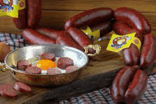 a pan filled with sausages and an egg on a table .