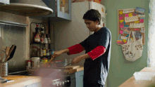 a man is preparing food in a kitchen with a sign on the wall that says ' no more '