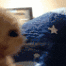 a close up of a baby 's face with a blue blanket with stars on it