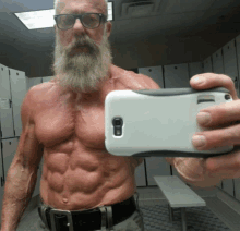 a man with a beard is taking a selfie in a gym