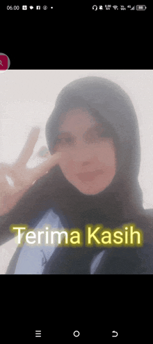 a woman in a hijab is giving a peace sign and the words terima kasih are on the screen