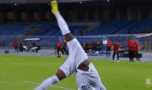 a soccer player is doing a handstand on the field while wearing a jersey that says ' gazprom ' on it