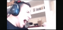 a man wearing headphones and a microphone is screaming while playing a video game .