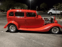 a red car is parked in a parking lot