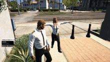 a man and a woman are standing on a sidewalk in front of a sign that says central de aires