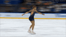 a woman in a blue dress is ice skating in a warm-up group 4 of 4 finlandia trophy ladies fs