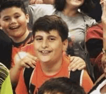 a group of children are sitting in a stadium and one of them is smiling .