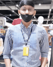 a man wearing a striped shirt and a lanyard with a name tag that says ivan on it