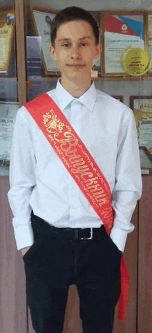 a young man wearing a sash that says ' aleksandr '