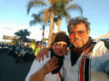 a man wearing a harley davidson jacket stands with a woman