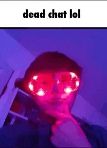 a person wearing glow in the dark glasses is making a face .