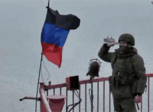 a soldier salutes in front of a flag